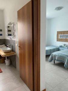 uma casa de banho com um lavatório e uma porta num quarto em CasaNobile "Il Grano" em Merate