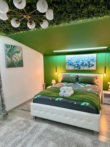- une chambre avec un grand lit et un mur vert dans l'établissement DeyInn Guest House Centrum, à Turda
