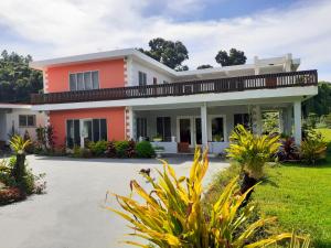 una casa con un césped verde delante de ella en Pacific Paradise Villa, en Sigatoka