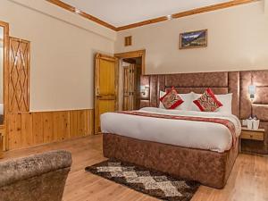 a bedroom with a large bed and a couch at SOLANG SKI RESORT MANALI in Palchān