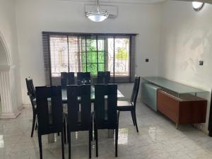 una sala da pranzo con tavolo e sedie nere di Royal Diadem Villa a Ile-Ife