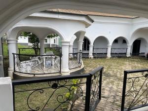 a building with a balcony with a gate and columns at Royal Diadem Villa in Ile-Ife