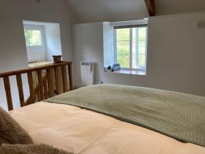 a bedroom with a bed and a window at The Barn at Tanlake in Buckland St Mary