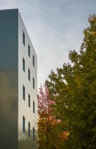 a tall white building next to some trees at B5 Boutique Hotel - NEW OPENING in Lugano