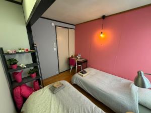 2 letti in una camera con pareti rosa di Keramiek Arita a Arita