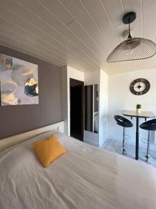 1 dormitorio con cama y mesa con taburetes en Studio Centre Port avec piscine résidence Port Richelieu en Cap d'Agde