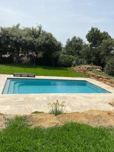 uma piscina com um banco num campo em Magnifique Villa à 10 mn des Plages avec Piscine pour 6 Personnes em Le Beausset
