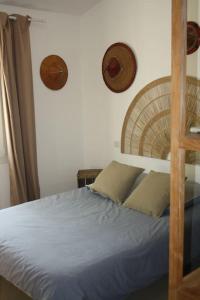 um quarto com uma cama com lençóis e almofadas azuis em Magnifique Villa à 10 mn des Plages avec Piscine pour 6 Personnes em Le Beausset