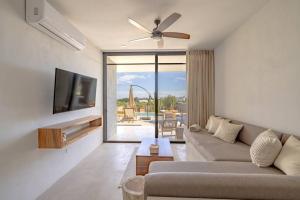 a living room with a couch and a flat screen tv at Baja Winds Condo poolside in La Ventana