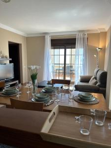 a living room with a table with plates and wine glasses at A estribor in Isla Canela
