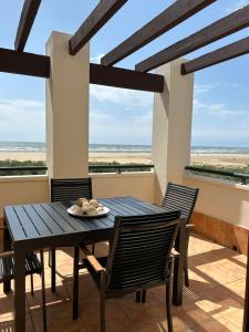 a table and chairs on a balcony with a view of the ocean at A estribor in Isla Canela