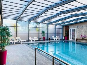 une grande piscine avec des chaises dans l'établissement Hotel & Spa Gil de France Cap d'Agde, au Cap d'Agde