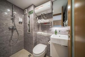 a bathroom with a shower and a toilet and a sink at Gepai Executive Apartment - Shenzhen Futian Convention and Exhibition Center in Shenzhen