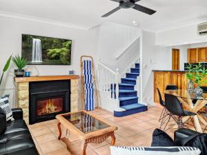 a living room with a fireplace and a staircase at Haven @ Lake Tinaroo Resort in Tinaroo