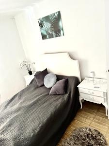una camera con letto nero e 2 cuscini di Relax Casa Costa Blanka a Santa Pola