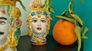 een standbeeld van een vrouw met een sinaasappel op een tafel bij Location10 in Palermo