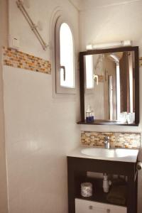 y baño con lavabo y espejo. en Hôtel le Nid, en Argelès-sur-Mer