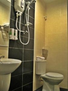 a bathroom with a toilet and a sink at GM Holiday Hotel in Lumut