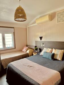 a bedroom with two beds and a ceiling at Hôtel le Nid in Argelès-sur-Mer