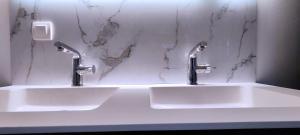 twee wastafels in een badkamer met twee kranen bij Vrijstaande woning gelijkvloers in Zemst