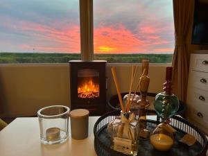 Ein Tisch mit Kamin und Blick auf den Sonnenuntergang in der Unterkunft Traumblick Nr 3 aufs Wattenmeer Blick bis nach Texel in Dam + 18 Fotos