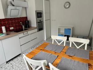a kitchen with white cabinets and a table and chairs at FeWo beim Schmetterlings Park in Buchholz in der Nordheide