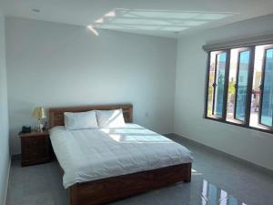 ein Schlafzimmer mit einem Bett und zwei Fenstern in der Unterkunft Hong Kong Hotel in Haiphong