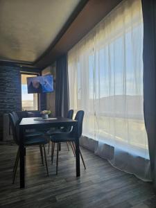 a dining room with a table and chairs and a window at Apartment 22 in Veliko Tŭrnovo