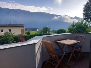 a table and two chairs on a balcony with mountains at Ferienwohnung Goldeckblick in Seeboden