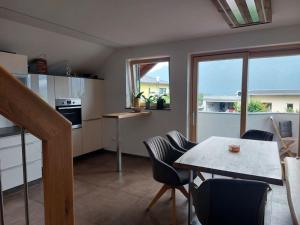 a kitchen with a table and chairs and a kitchen with a window at Ferienwohnung Goldeckblick in Seeboden +6 photos