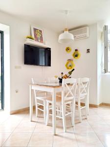 a white dining room with a white table and chairs at Apartment Megi in Supetar historical core in Supetar