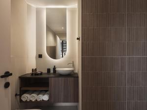 a bathroom with a sink and a mirror at Copal Simple Staying in Chania Town