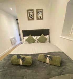 een slaapkamer met een bed met twee bogen erop bij Detached Studio Apartment n Sutton/Croydon in Banstead