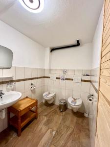 a bathroom with two toilets and a sink at Holiday House Lärchenheim in Saas-Balen