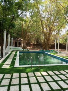 una piscina en un patio con árboles en Surya Eco and Wedding Resort, en Trichūr