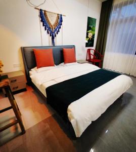 1 dormitorio con 1 cama grande con almohadas de color naranja y negro en Flower Yard en Huairou