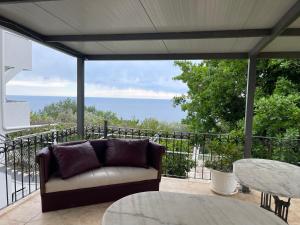 a couch on a patio with a view of the ocean at Kuća Radović in Budva