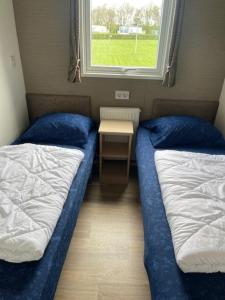 - 2 lits dans une chambre avec une table et une fenêtre dans l'établissement Traumblick, Traumlage Nr 31 erste Reihe direkt am Wattenmeer, à Westerland