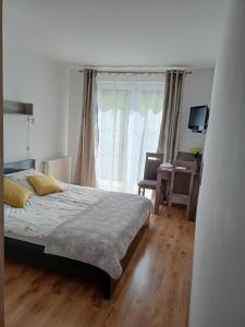 een slaapkamer met een bed en een groot raam bij Villa Over Lake in Mielno