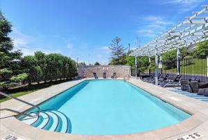uma grande piscina com cadeiras e uma piscina em Holiday Inn Express Whitby Oshawa, an IHG Hotel em Whitby