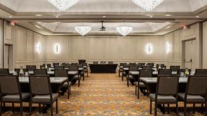 uma sala de conferências com mesas, cadeiras e lustres em Holiday Inn Winnipeg-South, an IHG Hotel em Winnipeg