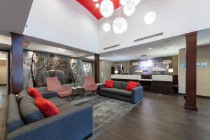 a lobby with couches and chairs and a kitchen at Holiday Inn Express & Suites Riverport Richmond, an IHG Hotel in Richmond