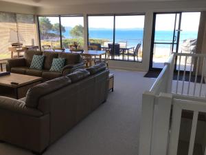 una sala de estar con sofás y vistas al océano. en Swansea Beach House Oceanfront, en Swansea
