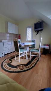 een woonkamer met een tafel en 2 stoelen bij Apartment Dobra vila in Perućac