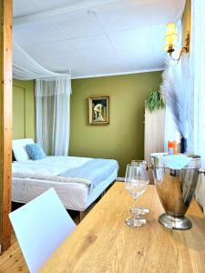 1 dormitorio con 1 cama y 1 mesa con copas de vino en Guesthouse 'Blue House' in vintage villa&garden, en Copenhague