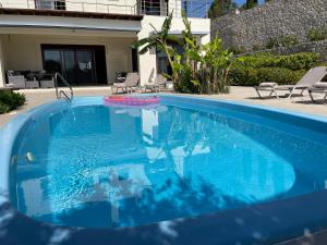 a blue swimming pool with a pink frisbee in it at Villa Chrysa Rhodes in Afantou