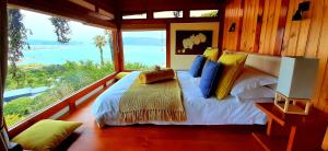a bedroom with a bed and a large window at Paradise Private Zen Studios in Knysna