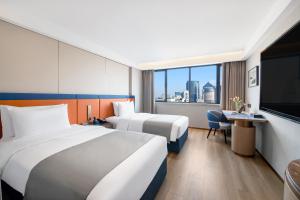 杭州市にあるLan'ou International Hotel - Wulin Square West Lakeのベッド2台、薄型テレビが備わるホテルルームです。