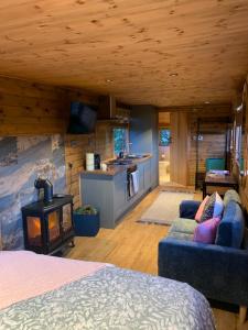 a room with a bed and a kitchen with a stove at The Showman, Luxury Camper in Halford