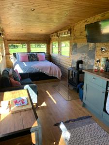 a bedroom with a bed and a couch in a room at The Showman, Luxury Camper in Halford